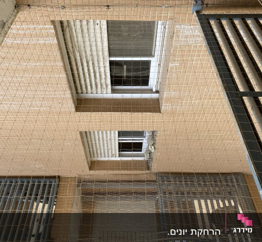 רשת למניעת כניסת יונים על קיר בניין